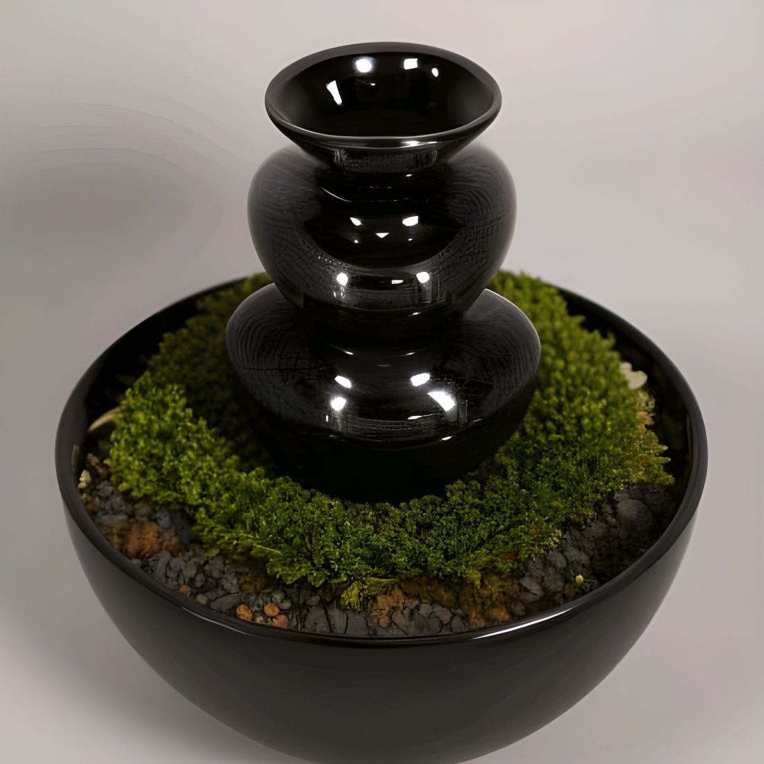 A shiny black voluptuous vase sits in a bowl of garden